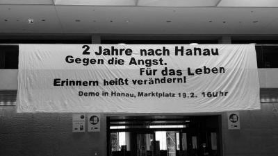 Banner zum Jahrestag des rassistischen Anschlags von Hanau im PEG-Gebäude der Universität