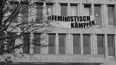 Banner mit der Aufschrift "Feministisch kämpfen" am PEG-Gebäude